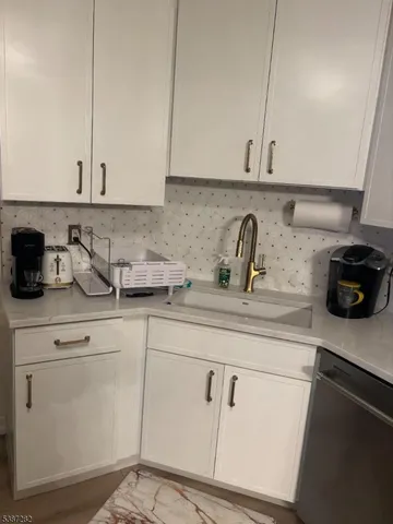 a kitchen with white cabinets and a sink