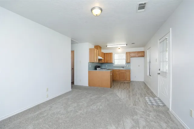 a large kitchen with cabinets and a window