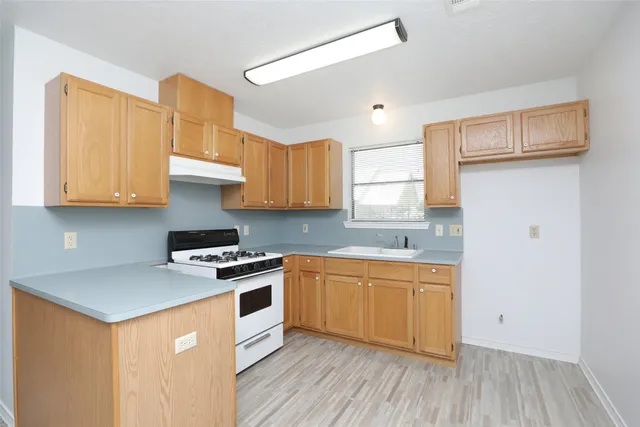 a kitchen with stainless steel appliances granite countertop a sink a stove and a refrigerator