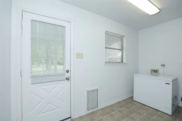 a view of an empty room with closet and a window