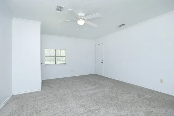 an empty room with windows and ceiling fan