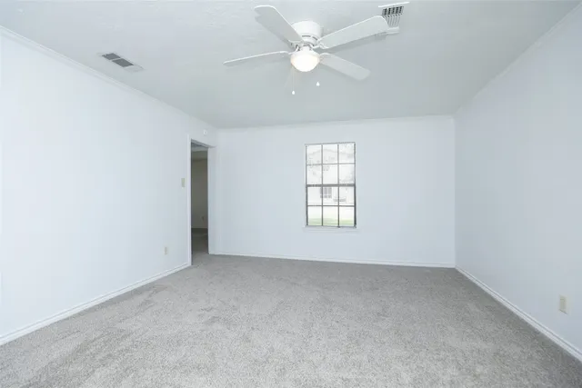 an empty room with a window and a ceiling fan