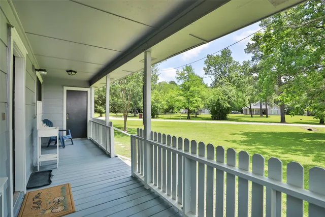 a view of a porch with wooden floor and fence