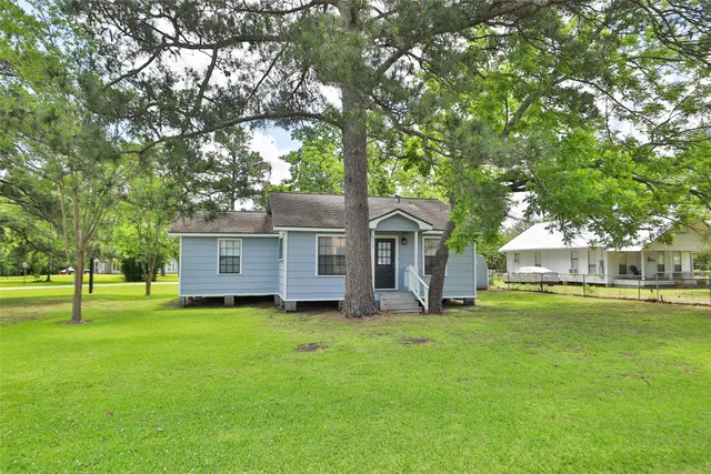 a large house with a big yard and large trees