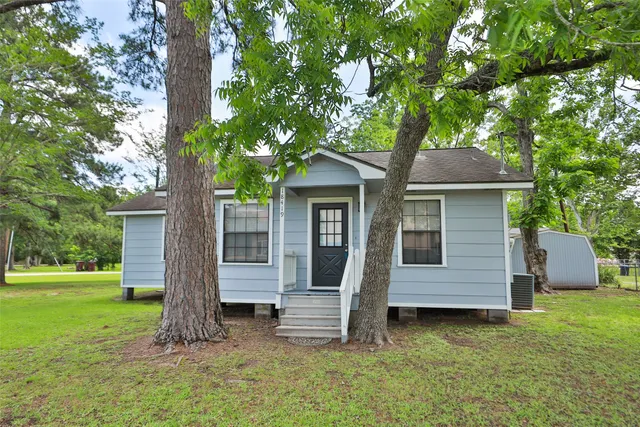 a front view of a house with a garden and yard