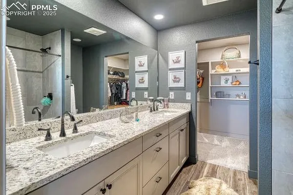 a bathroom with a granite countertop bathtub shower sink vanity and toilet
