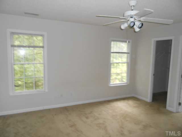 2409 Finley Ridge Lane Raleigh, NC 27615 - Photo 7 of 8 an empty room with windows and fan