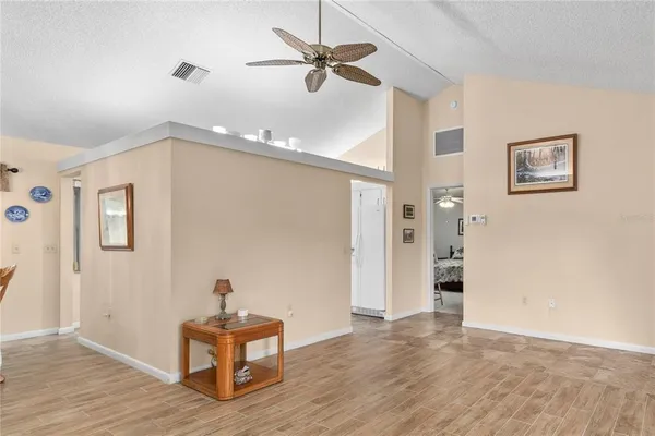 a view of an empty room with a window and wooden floor