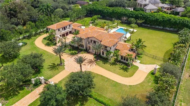 an aerial view of residential houses with outdoor space and trees