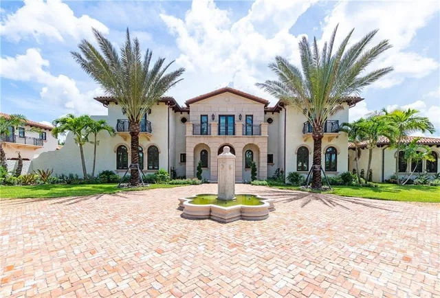 a front view of a house with a yard garage and fountain