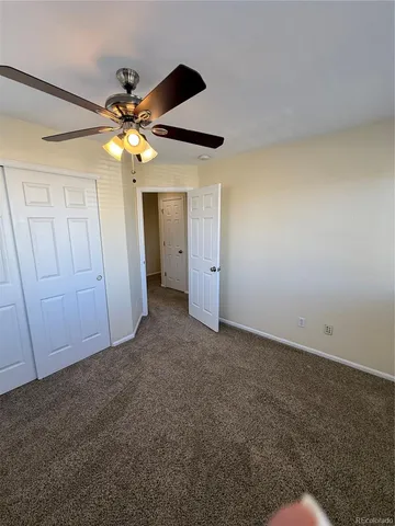an empty room with a fan and a fan