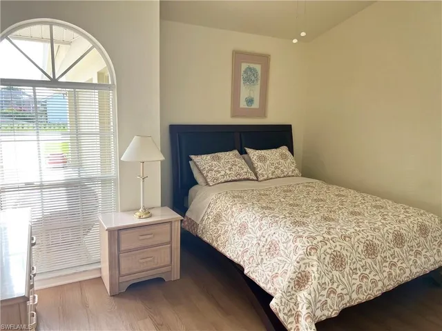 a bedroom with a bed and a large window