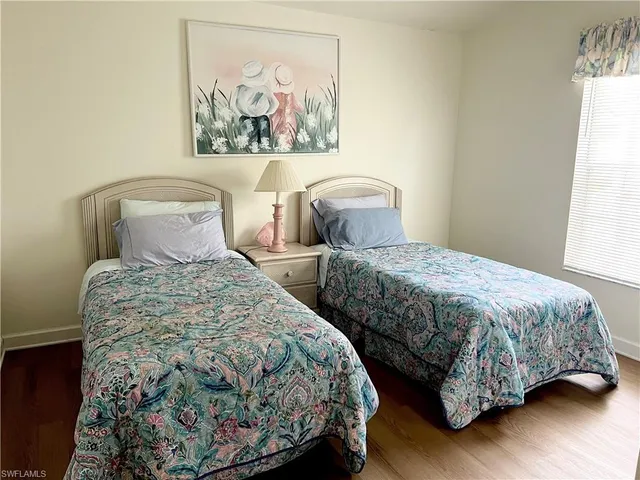 a bedroom with two beds and a painting on the wall