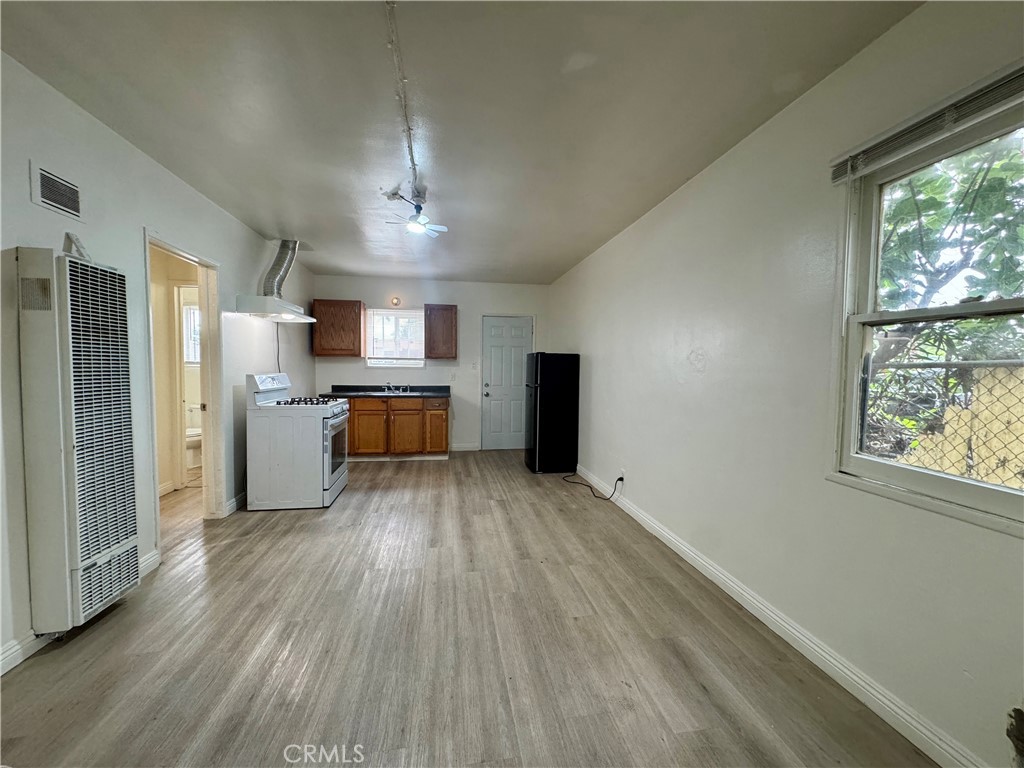 a view of kitchen with wooden floor electronic appliances and window