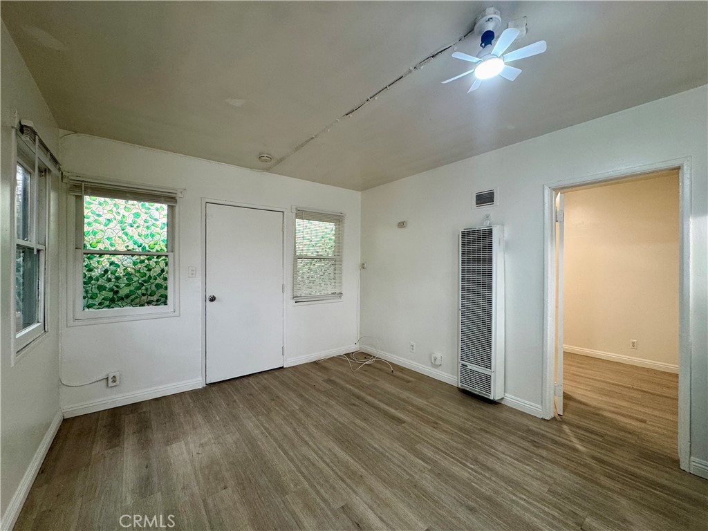 12616 Lambert Road, Unit 5 Whittier, CA 90602 - Photo 3 of 10 an empty room with wooden floor cabinet and windows