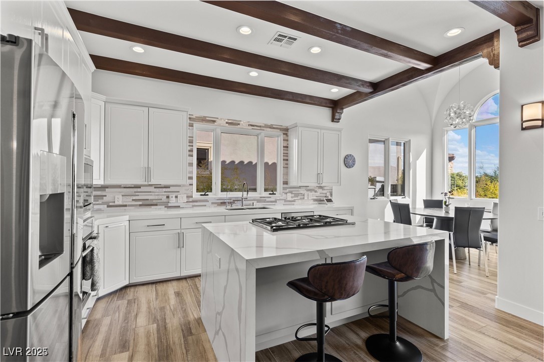 3 Rue Allard Way Henderson, NV 89011 - Photo 15 of 49 Kitchen with stainless steel appliances, a sink, white cabinetry, visible vents, and decorative backsplash