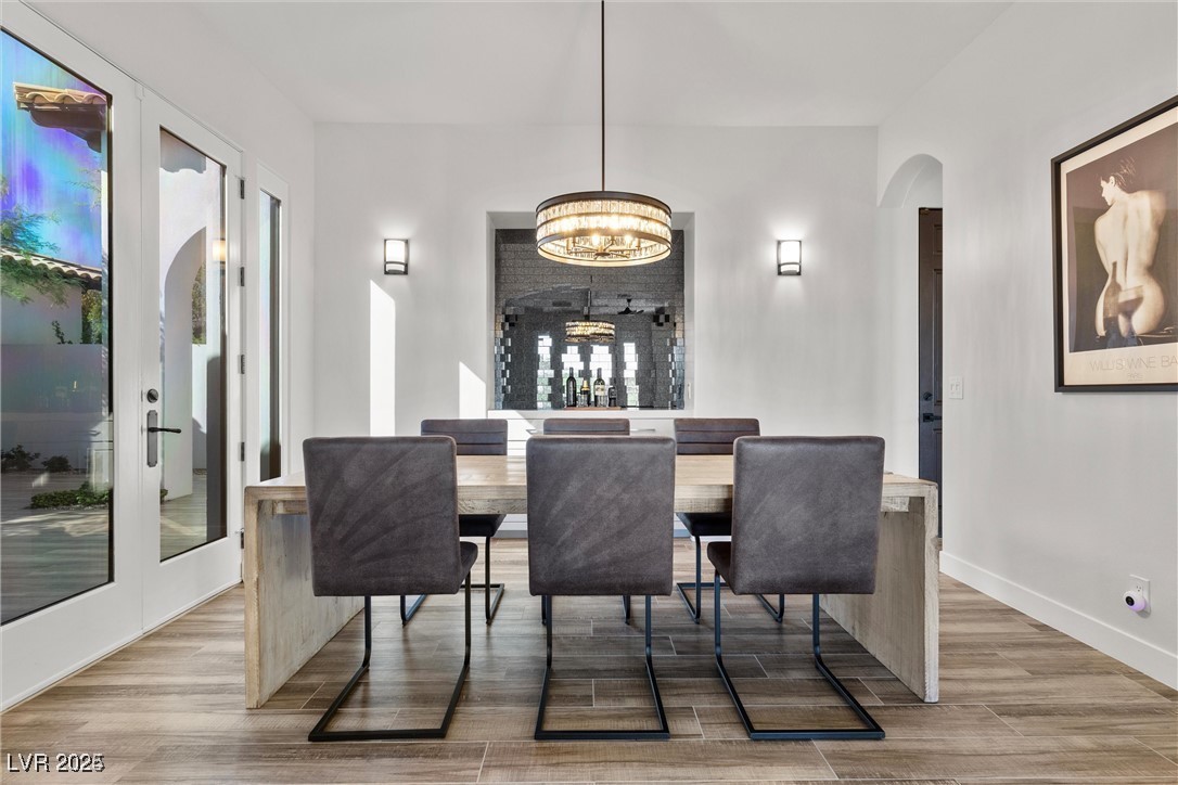3 Rue Allard Way Henderson, NV 89011 - Photo 19 of 49 Dining room with a notable chandelier, baseboards, arched walkways, and wood finished floors