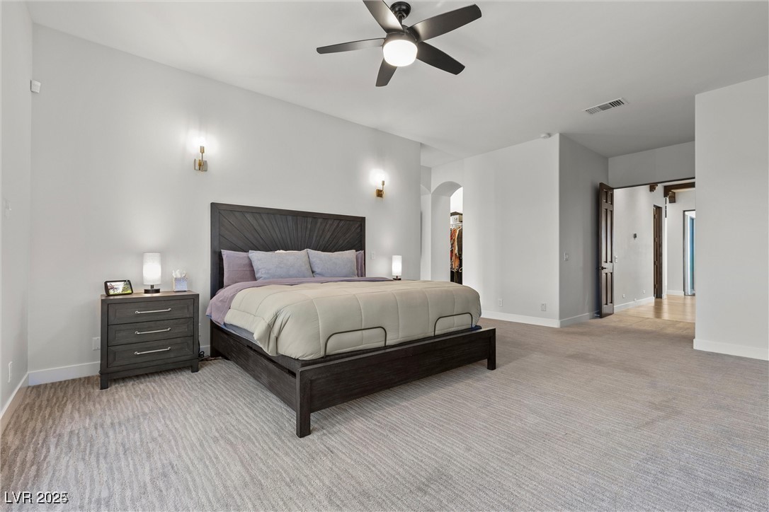 3 Rue Allard Way Henderson, NV 89011 - Photo 22 of 49 Bedroom with arched walkways, light colored carpet, visible vents, and baseboards
