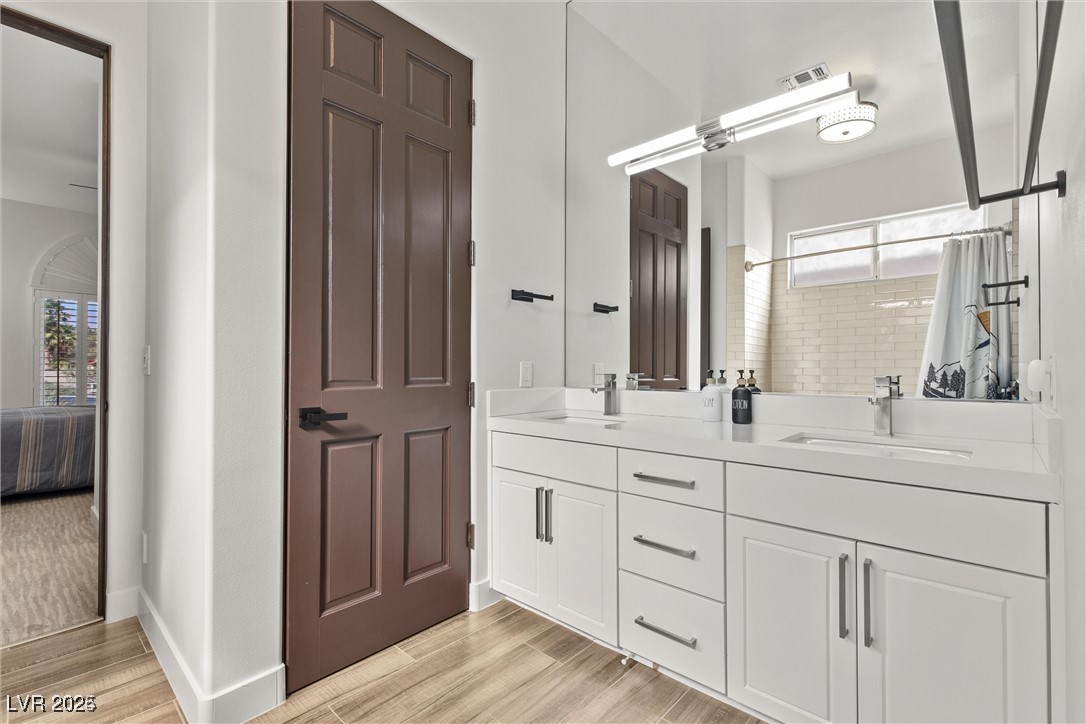 3 Rue Allard Way Henderson, NV 89011 - Photo 27 of 49 Ensuite bathroom featuring double vanity, a sink, and wood finished floors