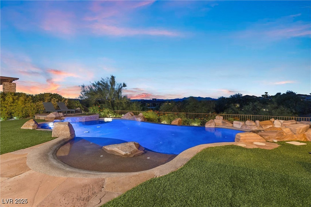 3 Rue Allard Way Henderson, NV 89011 - Photo 3 of 49 Pool at dusk featuring a fenced in pool, a patio area, a lawn, and fence