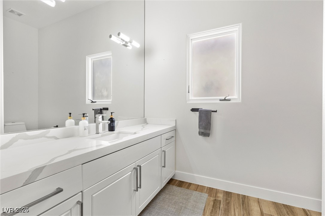 3 Rue Allard Way Henderson, NV 89011 - Photo 31 of 49 Bathroom featuring baseboards, visible vents, toilet, wood finished floors, and vanity