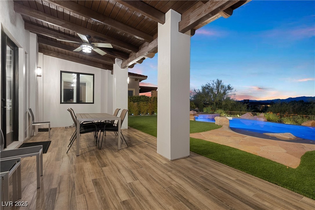3 Rue Allard Way Henderson, NV 89011 - Photo 32 of 49 Patio terrace at dusk featuring outdoor dining space, a ceiling fan, and a fenced in pool