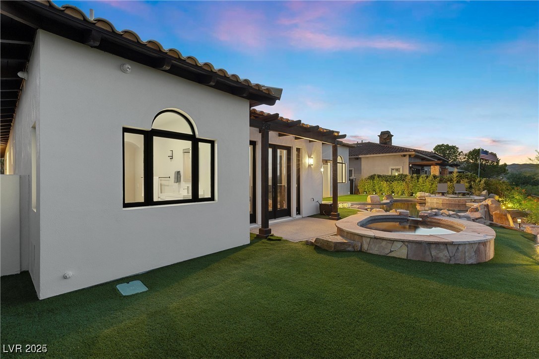 3 Rue Allard Way Henderson, NV 89011 - Photo 35 of 49 Back of property at dusk featuring stucco siding and a yard
