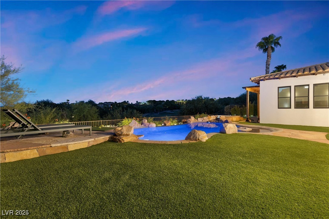 3 Rue Allard Way Henderson, NV 89011 - Photo 37 of 49 Pool at dusk featuring an outdoor pool, a patio area, and a lawn