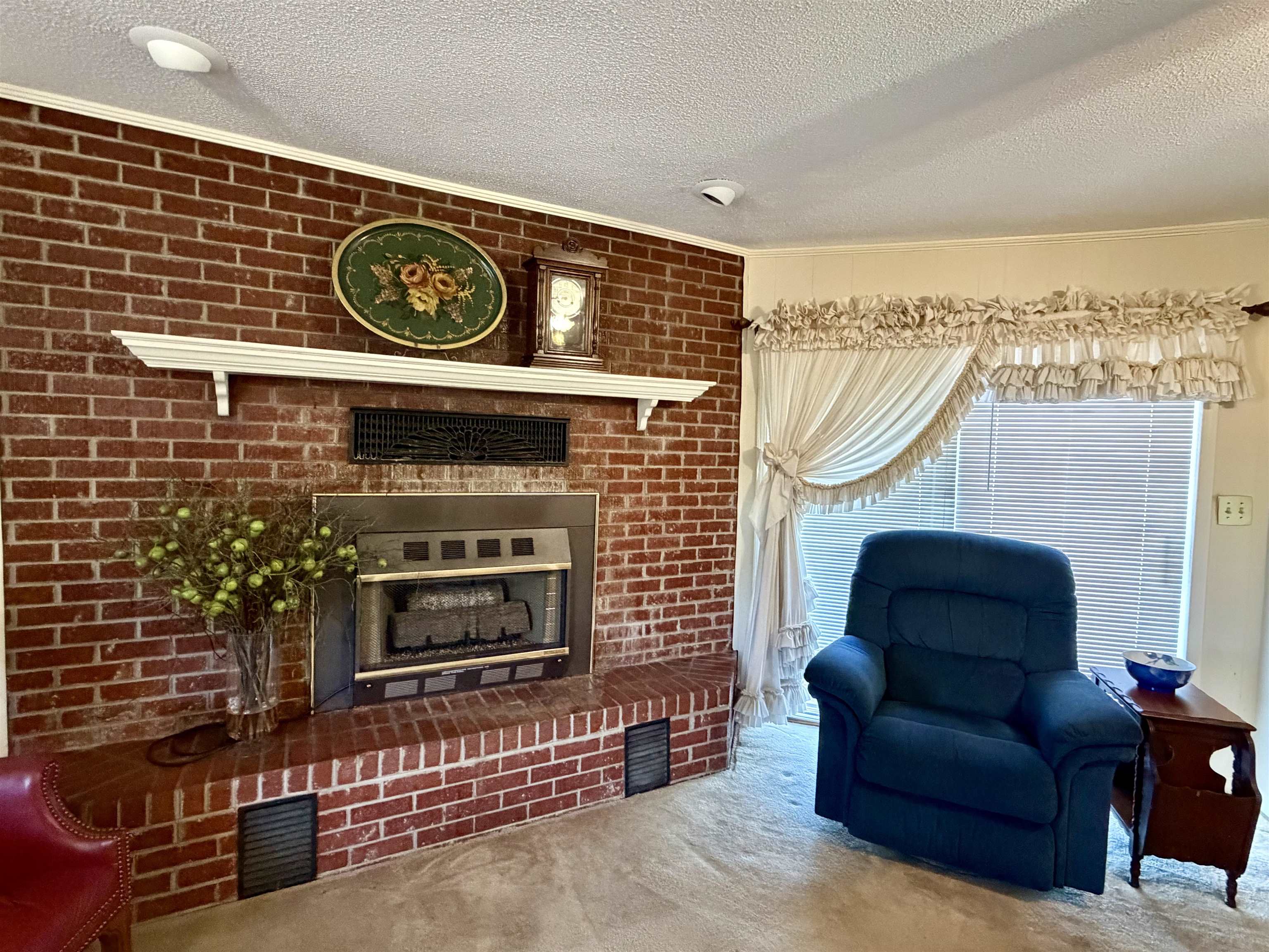 192 New Bethel Road Selmer, TN 38375 - Photo 12 of 27 Sitting room featuring carpet floors, a fireplace, a textured ceiling, and brick wall