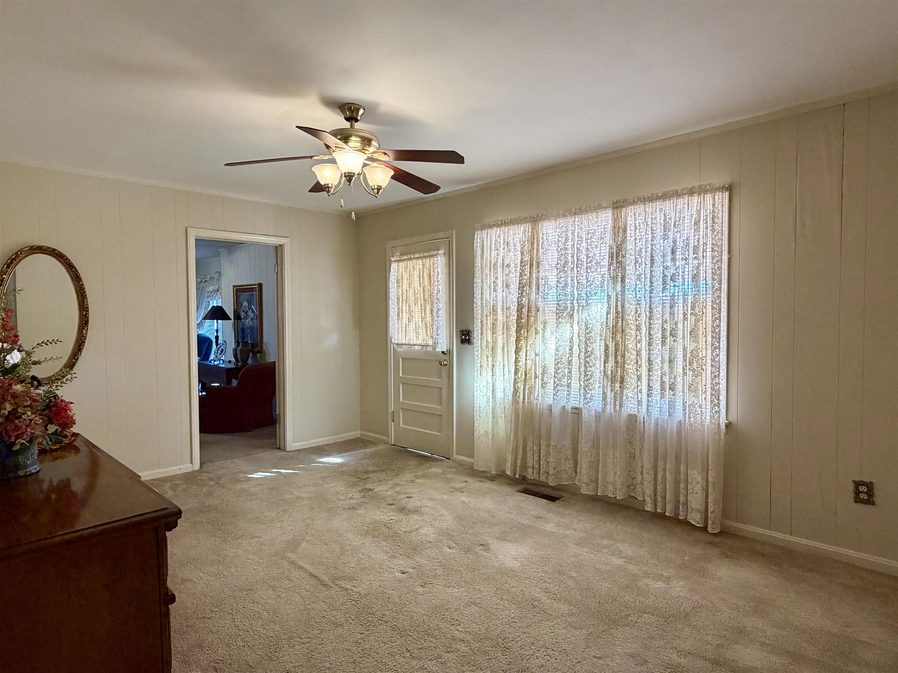 192 New Bethel Road Selmer, TN 38375 - Photo 22 of 27 Foyer entrance with wooden walls, carpet floors, and a ceiling fan