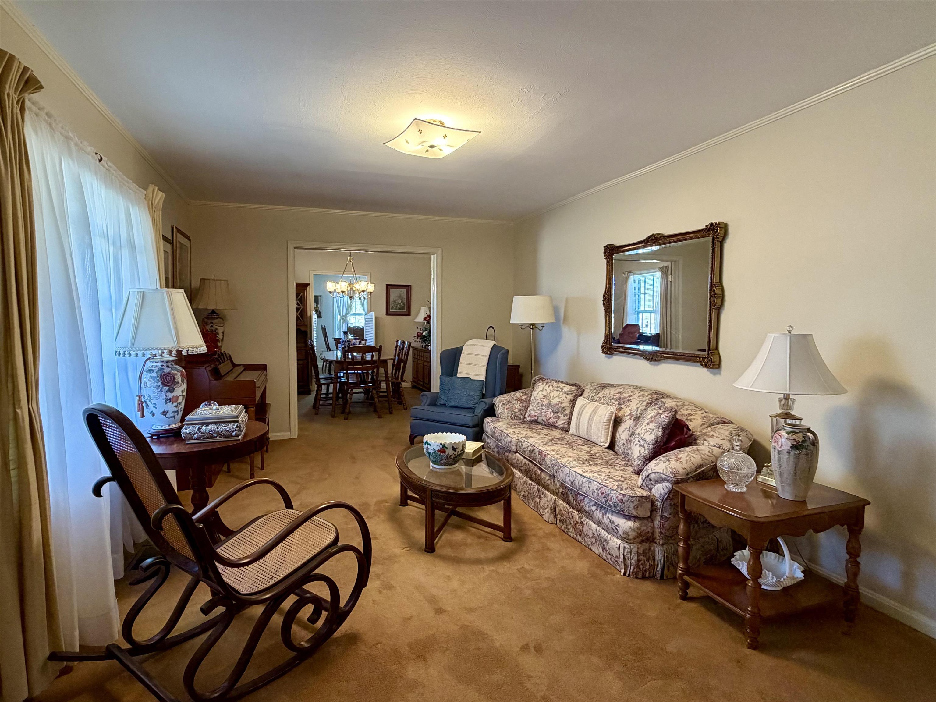 192 New Bethel Road Selmer, TN 38375 - Photo 4 of 27 Living area featuring carpet floors, suspended lighting, healthy amount of natural light, and crown molding