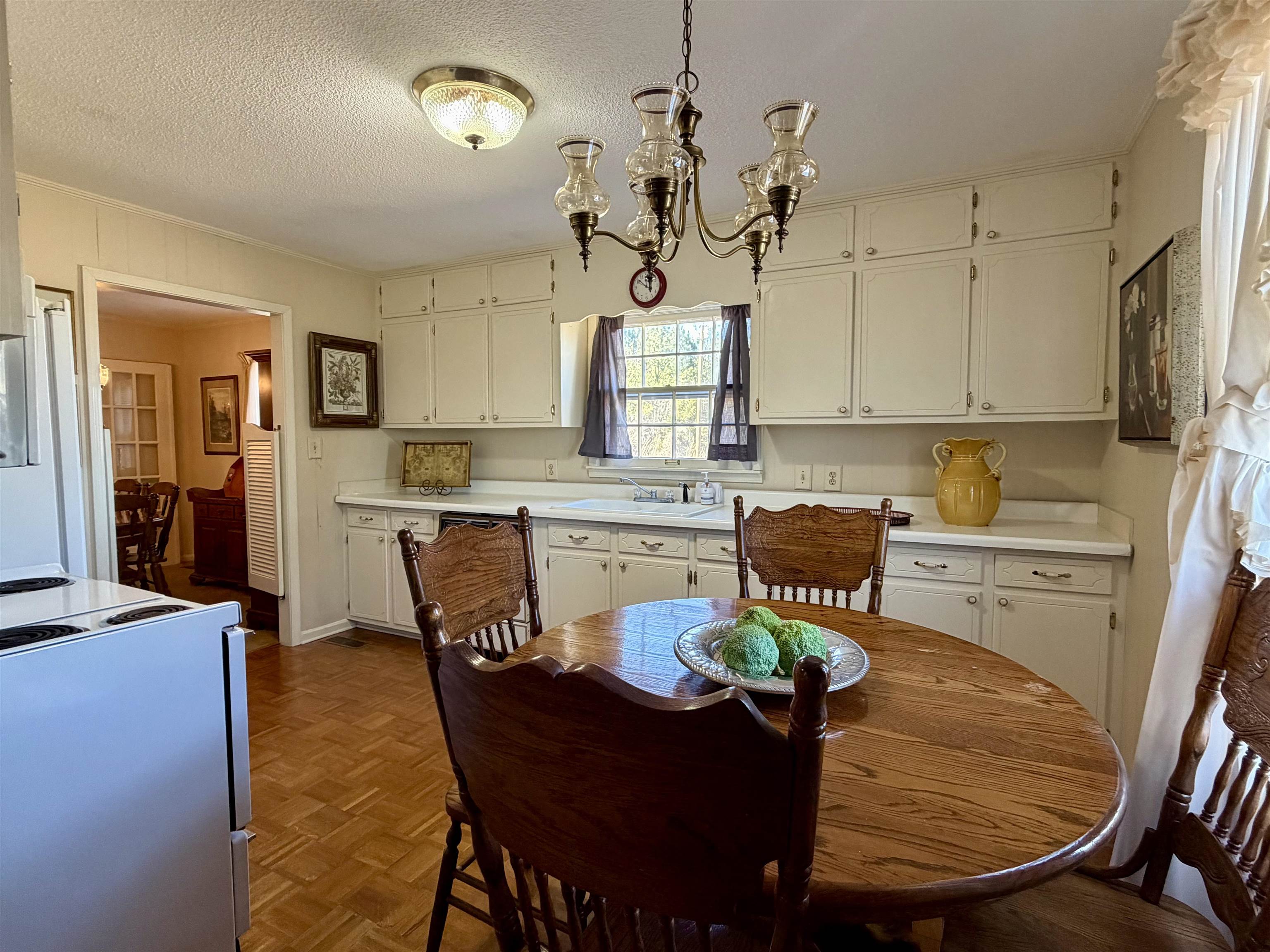 192 New Bethel Road Selmer, TN 38375 - Photo 5 of 27 Kitchen featuring light countertops, parquet floors, suspended lighting, white range with electric stovetop, and a textured ceiling