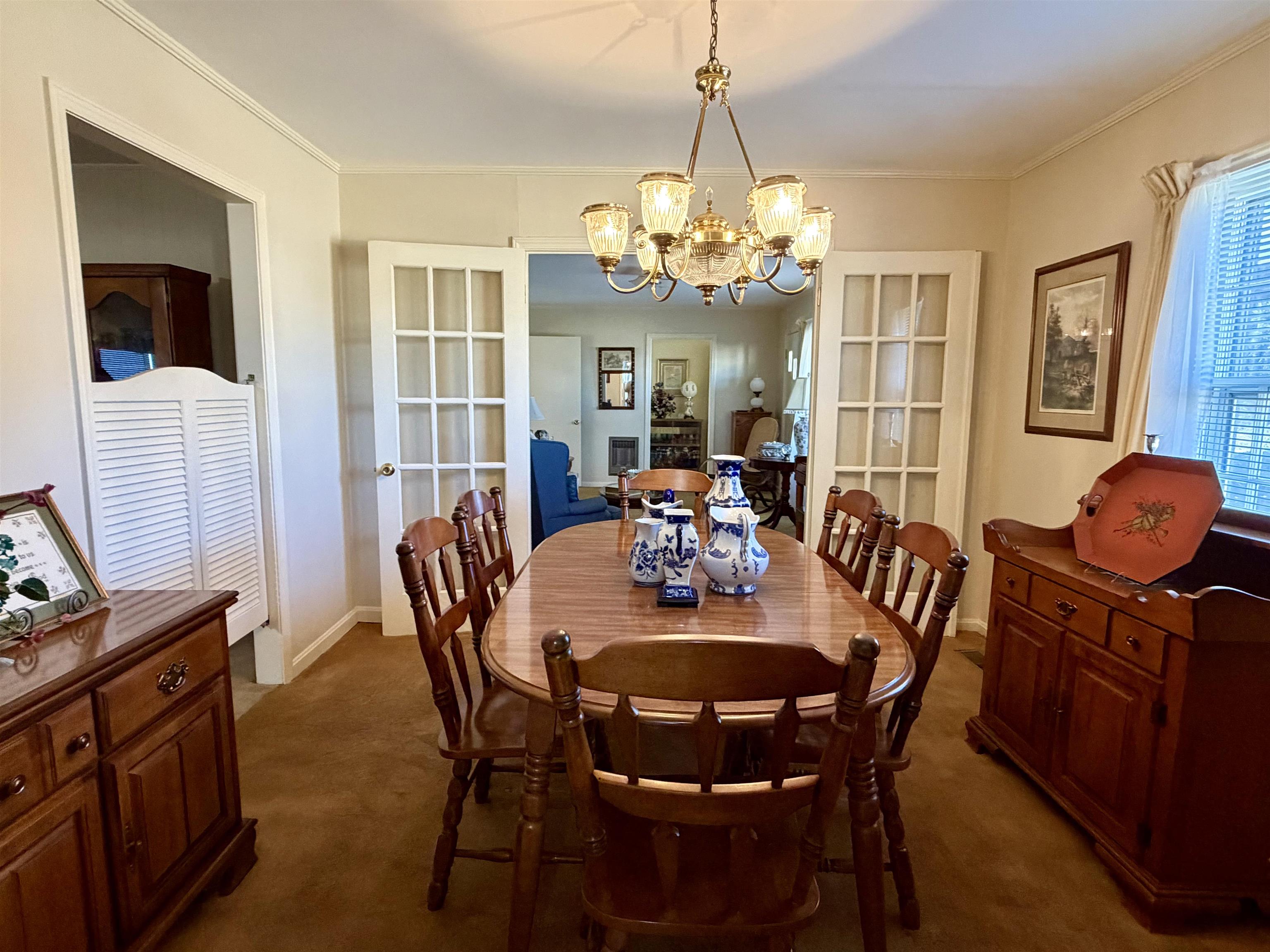 192 New Bethel Road Selmer, TN 38375 - Photo 9 of 27 Dining space with dark carpet, a chandelier, ornamental molding, and french doors