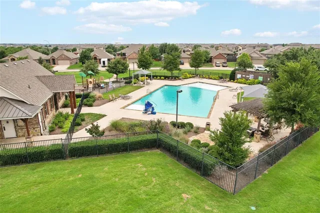 an aerial view of residential houses with outdoor space and trees