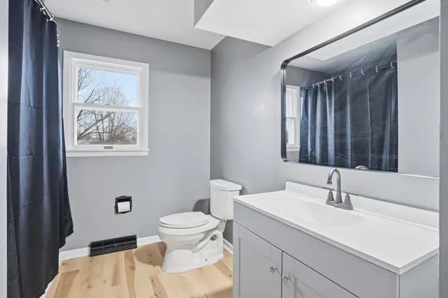 a bathroom with a sink a toilet and mirror