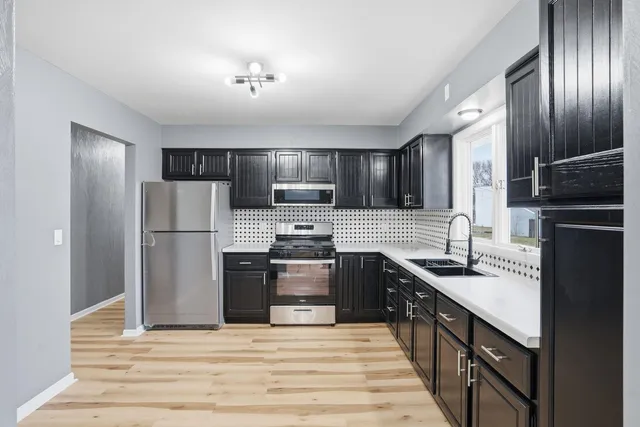 a kitchen with stainless steel appliances granite countertop a refrigerator stove microwave and sink