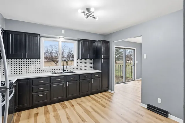 a kitchen with stainless steel appliances granite countertop a refrigerator a sink dishwasher and wooden cabinets with wooden floor