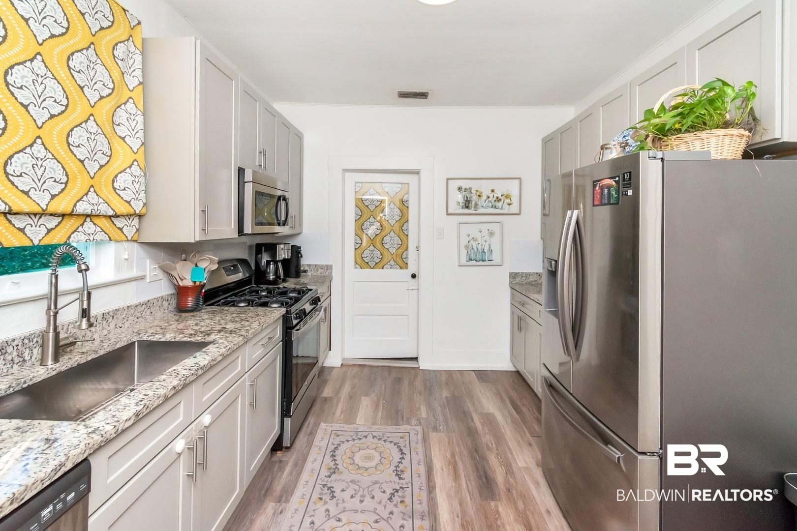 116 Item Avenue Mobile, AL 36607 - Photo 16 of 33 Kitchen featuring appliances with stainless steel finishes, light stone countertops, sink, and light wood-type flooring