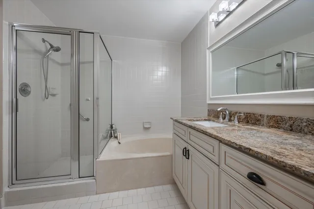 a bathroom with a granite countertop sink a toilet and shower