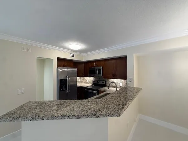 a kitchen with stainless steel appliances granite countertop a sink stove and refrigerator