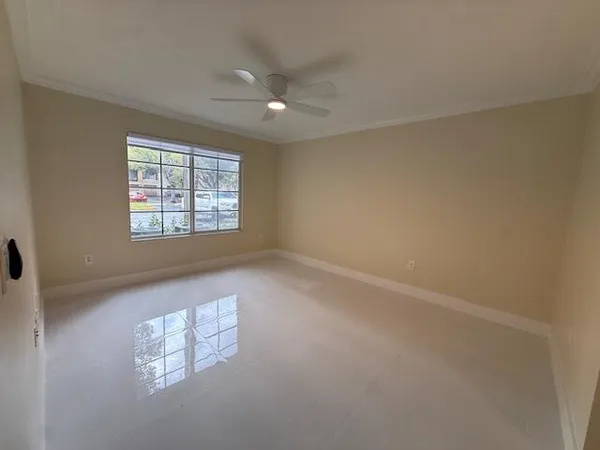 a view of empty room with wooden floor and ceiling fan