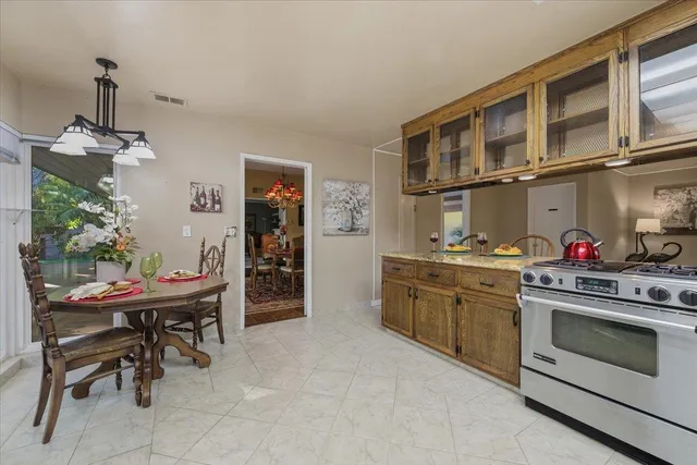 a kitchen with stainless steel appliances kitchen island granite countertop a table and chairs in it