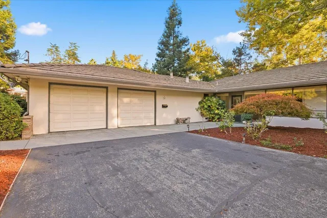 a view of a house with a yard and potted plants