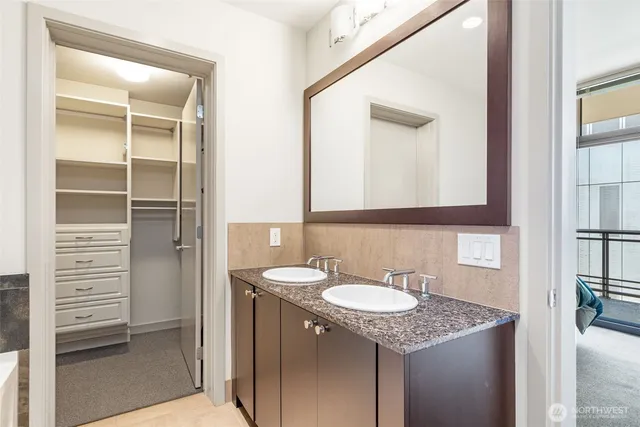 a bathroom with a granite countertop sink and a mirror