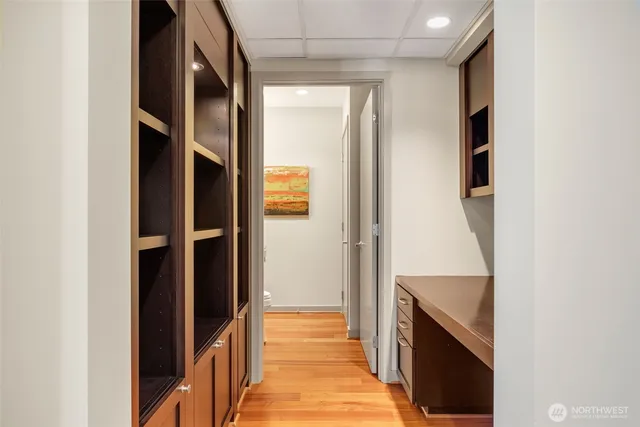 a hallway with cabinets and wooden floor