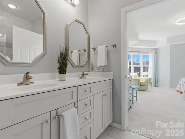 a en suite bathroom with a double vanity sink and a mirror