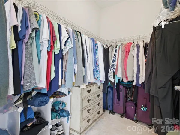 a view of walk in closet with clothes