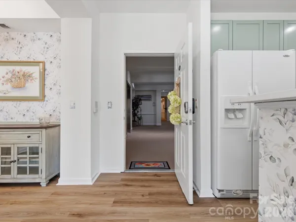 a view of a hallway with wooden floor and cabinets