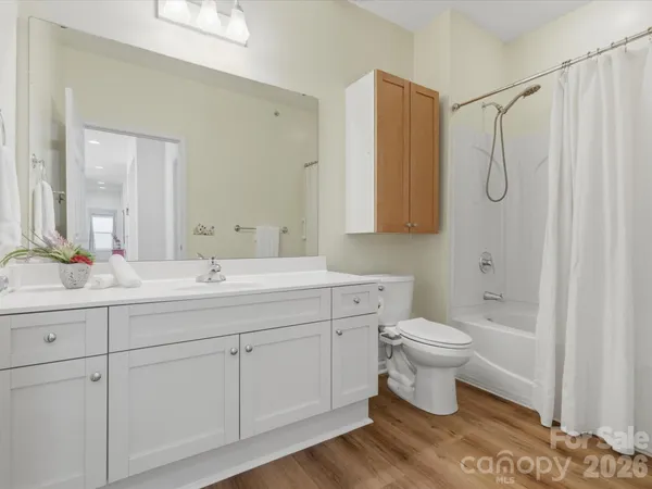a bathroom with a granite countertop toilet sink and mirror