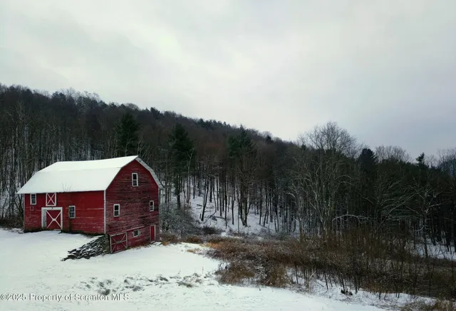 a view of a big house with a big yard and large trees
